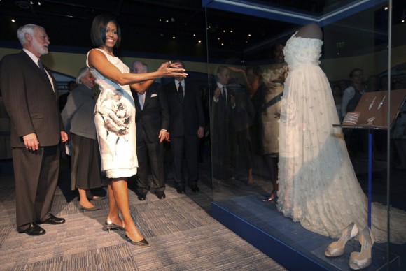 First lady Michelle Obama stands with the gown that she wore to the 2009 inaugural ball 580x388 Smithsonian Accepts Michelle Obamas Inaugural Ball Gown