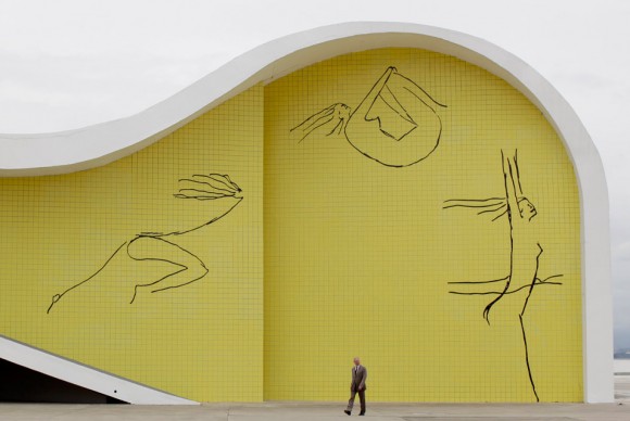 A man walks past a building designed by the Brazilian architect Oscar Niemeyer 580x388 Celebrated Brazilian Architect Oscar Niemeyer Turns 103, Opens Museum of His Work