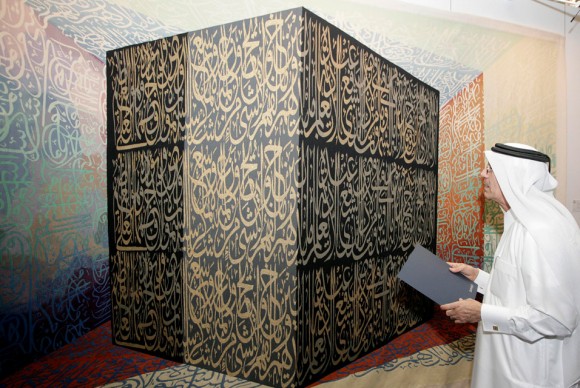 A visitor looks at a painting offered for sale in Doha December 12 2010 580x388 Sothebys Presents Works to Be Featured in Hurouf: The Art of the World Sale in Doha