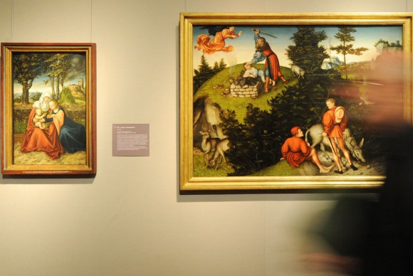 A man walks past the paintings L R St. Anna Selbdritt 1516 Abrahams Sacrifice 1530 and Adam and Eve 580x388 Selected Paintings by Lucas Cranach the Elder on View at Alte Pinakothek in Munich