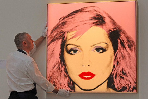 A Sothebys employee poses with artist Andy Warhols artwork Debbie Harry 580x388 Andy Warhols Portrait of Debbie Harry, A Highlight of Sothebys Contemporary Art Sale