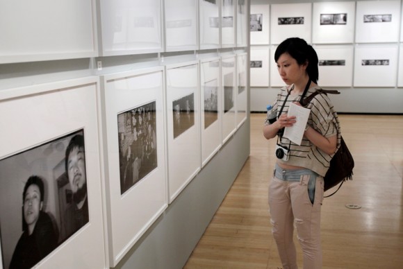 A visitor looks at photographs by Chinese artist Ai Weiwei during a preview of an exhibit at the Asia Society in New York 580x388 Ai Weiwei: New York Photographs Exhibition Opens at the Asia Society Museu