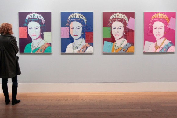 A woman looks at silkscreen prints by Andy Warhol 580x388 The Queen: Art and Image at the National Gallery Complex Celebrates Diamond Jubilee